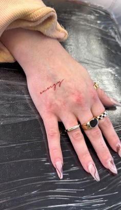 a woman's hand with a small tattoo on it