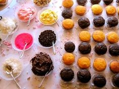 a table topped with lots of cupcakes covered in frosting