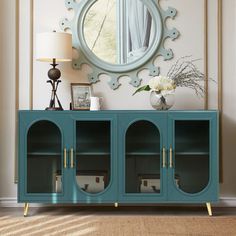 a blue cabinet with three doors and a round mirror on the wall in front of it