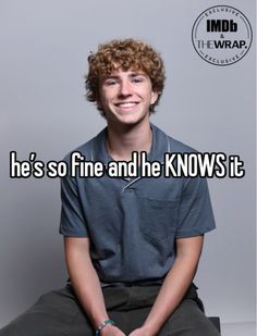 a man with curly hair sitting on the ground