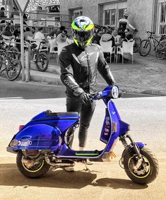 a man standing next to a blue scooter