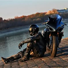 a person sitting on the ground next to a motorcycle