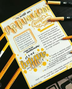 some pencils are laying on top of a yellow and white paper with the words congratulations written in cursive writing