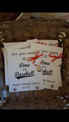 three wedding cards in a basket with red ribbon and heart charms on them, all you need is love and baseball