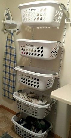 several laundry baskets stacked on top of each other next to a towel rack in a bathroom