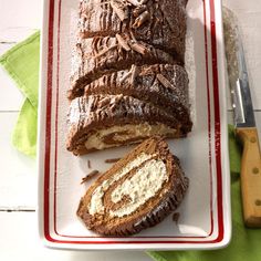 a loaf of chocolate marbled bread on a red and white plate next to a knife