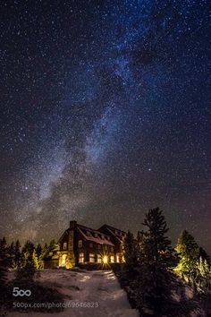 the night sky with stars above a house