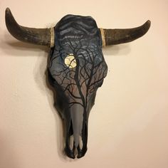 a bull's skull with long horns and trees painted on it