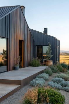 the house is made out of wood and has an open porch with steps leading to it