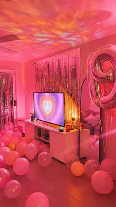 the room is filled with balloons, streamers and a television set in the center