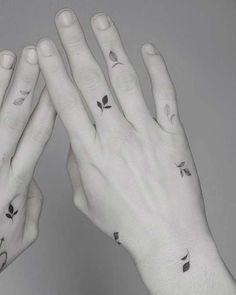 two hands are shown with small tattoos on them