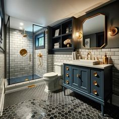 a bathroom with black and white tile, gold accents and blue cabinetry on the walls