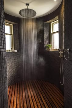 a shower head in the middle of a wooden floored room with windows on both sides