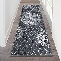 a black and white rug is on the floor next to an open door in a house