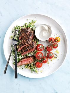 a white plate topped with steak and tomatoes