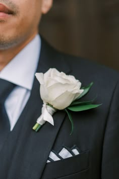 a man in a suit with a white flower on his lapel