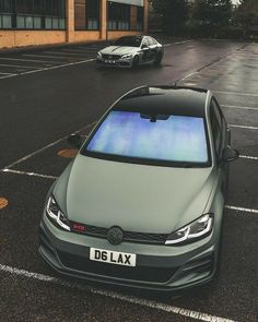 two cars parked next to each other in a parking lot with no one around them