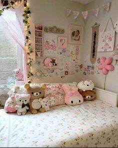 there is a bed with many stuffed animals on it in the room that has pink and white decor