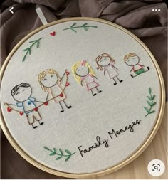 the embroidery on this hoop is very cute and it says, family matters with four people holding hands