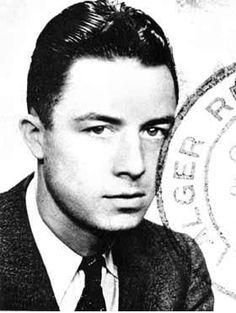 a black and white photo of a man in a suit looking at the camera with a serious look on his face