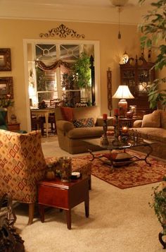 a living room filled with furniture and lots of plants in the middle of the room