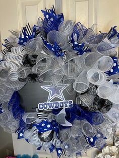 a wreath with the word cowboys on it is hanging in front of a white door