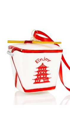 an ornament shaped like a bucket with chopsticks sticking out of it