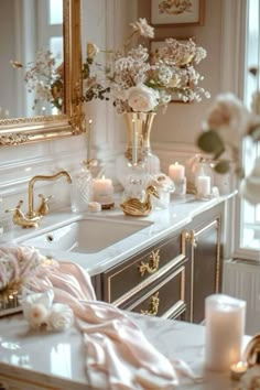 a bathroom sink with candles and flowers on it