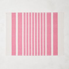 a pink and white striped rug on top of a floor next to a tablecloth