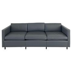 a gray leather couch with black legs