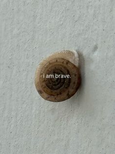 the word i am brave is written on a white wall with an old wooden door knob