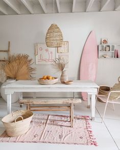 a white table and chairs in a room with surfboards on the wall behind it