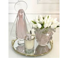 a glass vase with flowers in it on a tray