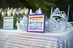 a table topped with crowns and cards on top of it