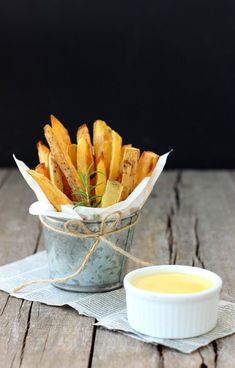 french fries with dipping sauce in a bowl on a napkin next to a small container