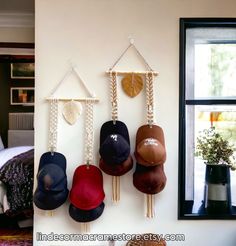 several hats hanging on the wall near a bed