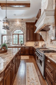 a large kitchen with wooden cabinets and marble counter tops