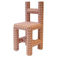 an orange and white chair made out of tiles on the back of it's seat