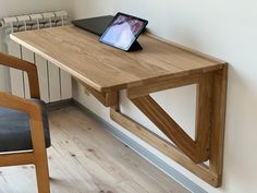 a wooden table with a tablet on it next to a chair and radiator