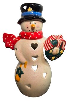 a ceramic snowman holding a candy cane