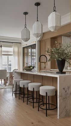 a kitchen with marble counter tops and stools next to an island in the middle