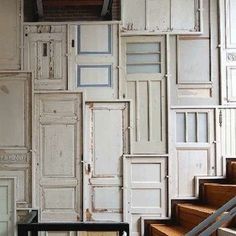 the stairs are lined with white doors and wooden steps