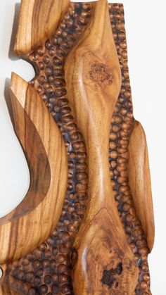 a wooden sculpture made out of wood with wavy designs on the top and bottom part