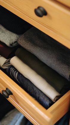 an open drawer with folded clothes in it