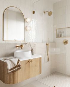 a bathroom with a sink, mirror and shower head in it's center area