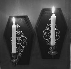 two candles are lit on the wall next to each other