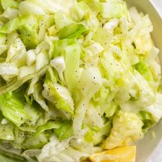 a white bowl filled with lettuce and orange slices