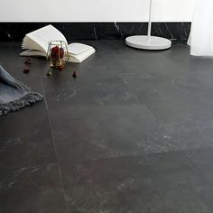 a room with black marble flooring and an umbrella on the ground next to it