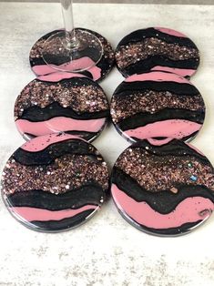 six pink and black coasters with glitter on them