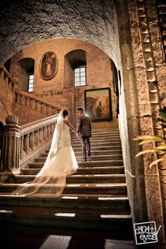 the bride and groom are walking down the stairs at their wedding ceremony in an old building